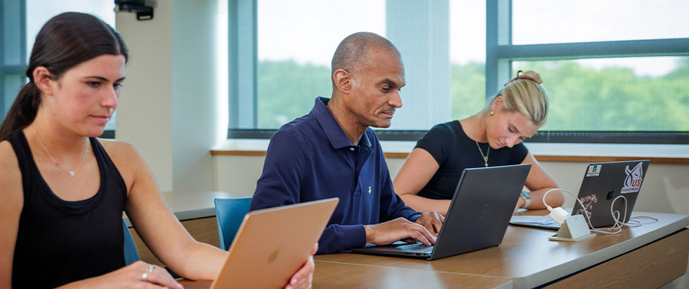 Students sitting at desks with laptops